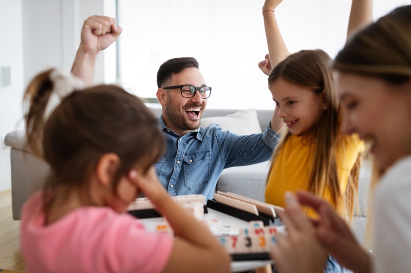 Happy family having fun, playing board game at home