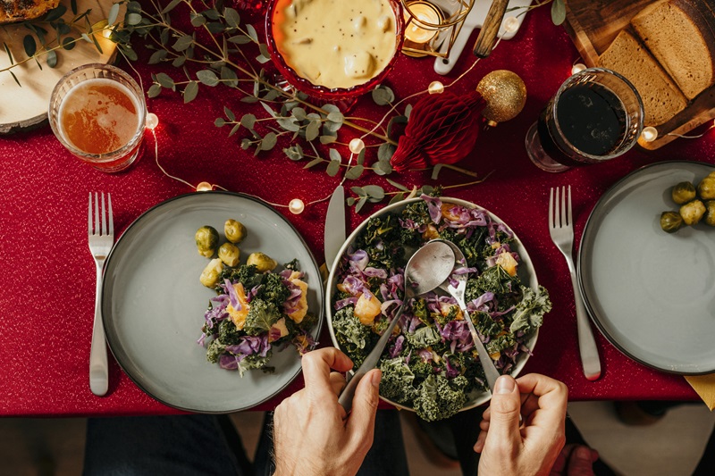 person serving themself healthy holiday side dish salad