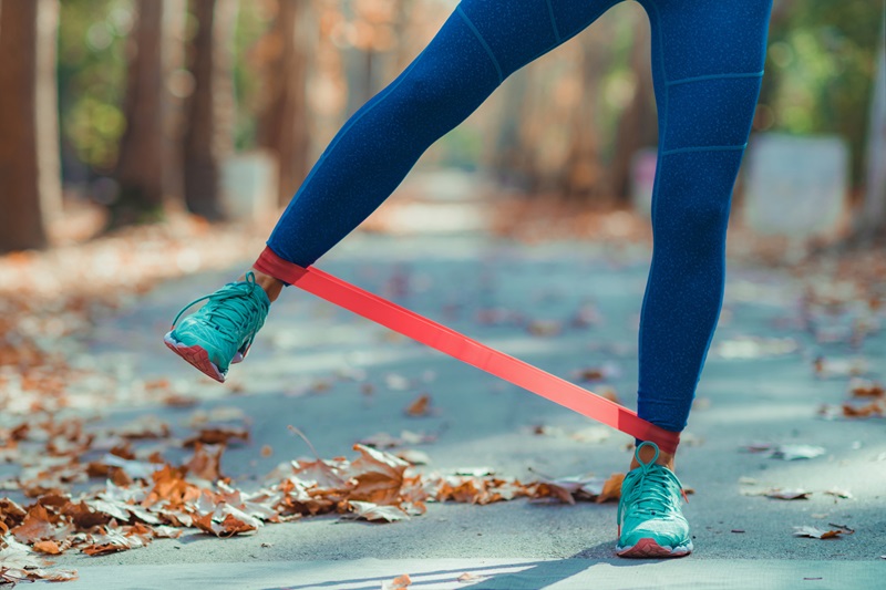 Woman Exercising Legs with Resistance Band Outdoors