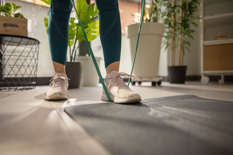 woman stepping on resistance band with one leg