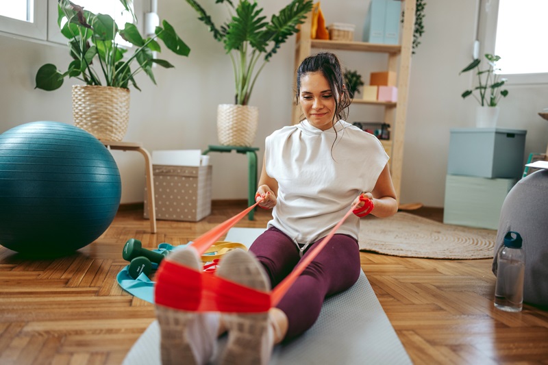 woman doing fitness training at home with resistance band