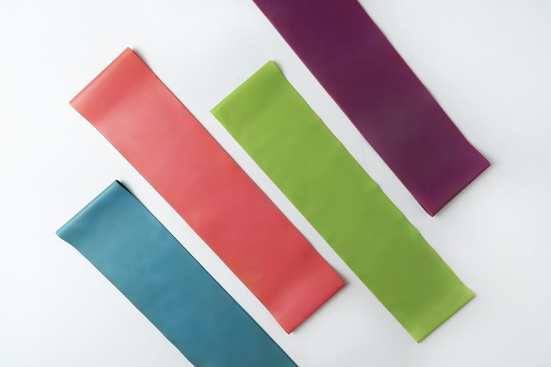 Colorful fitness resistance bands lying on the white floor