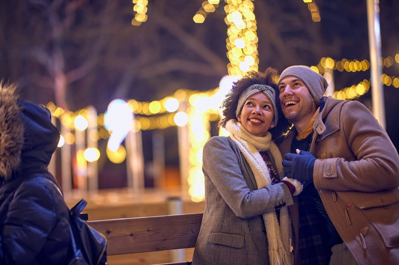 Happy man and woman on a Christmas walk in the city evening