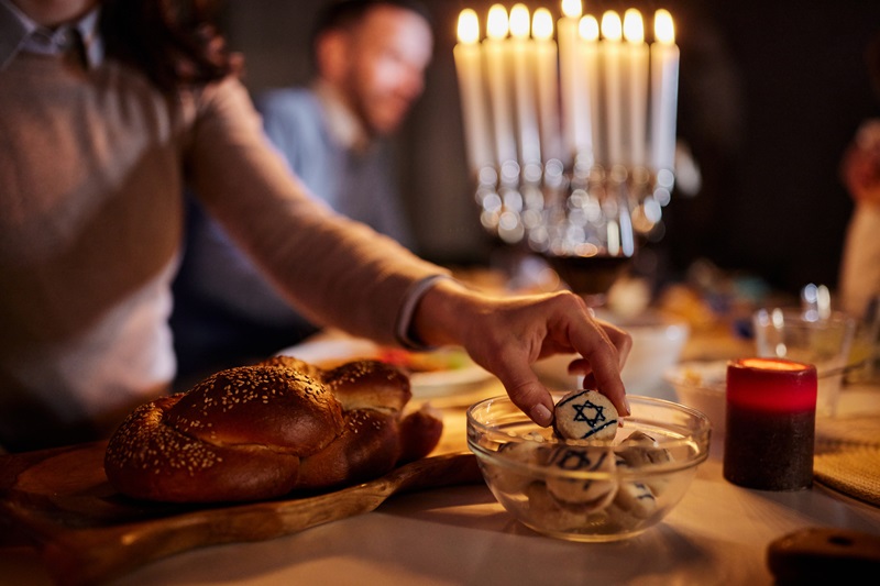 woman taking macaroons decorated with Star of David for the Jewish holiday Hanukkah.