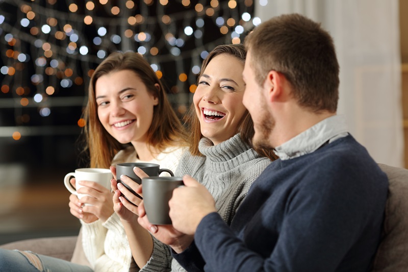 Three friends or family members talking and laughing on a couch