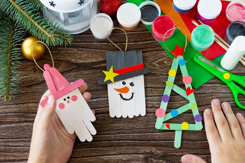 hand holding Christmas decoration or Christmas gift made from wooden sticks.