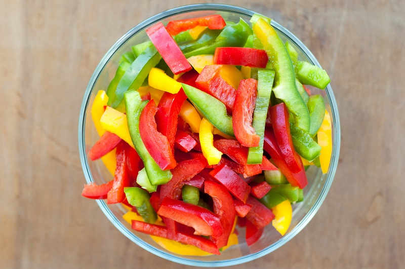 different colored bell peppers mixed in a glass bowl