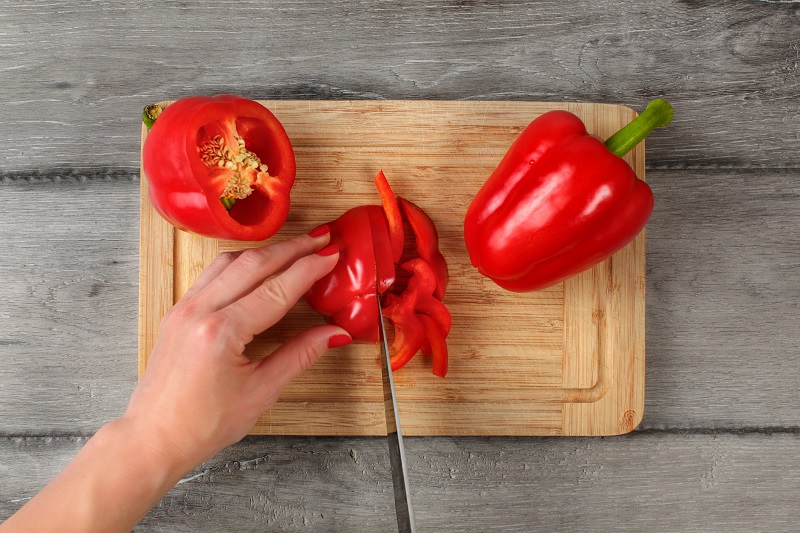 person cutting red bell peppers for healthy weight loss snacks
