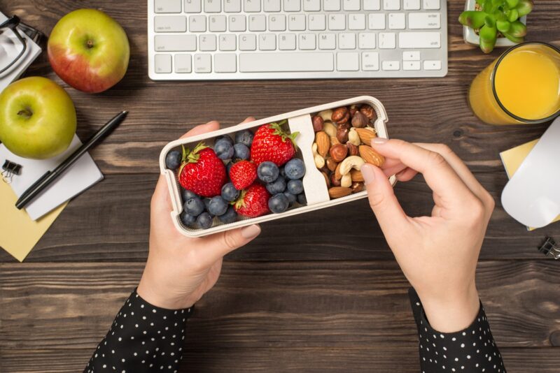 woman eating healthy snack at work