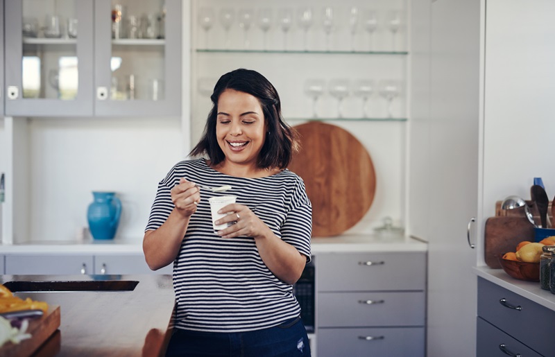 woman eating yogurt for a healthy snack for weight loss