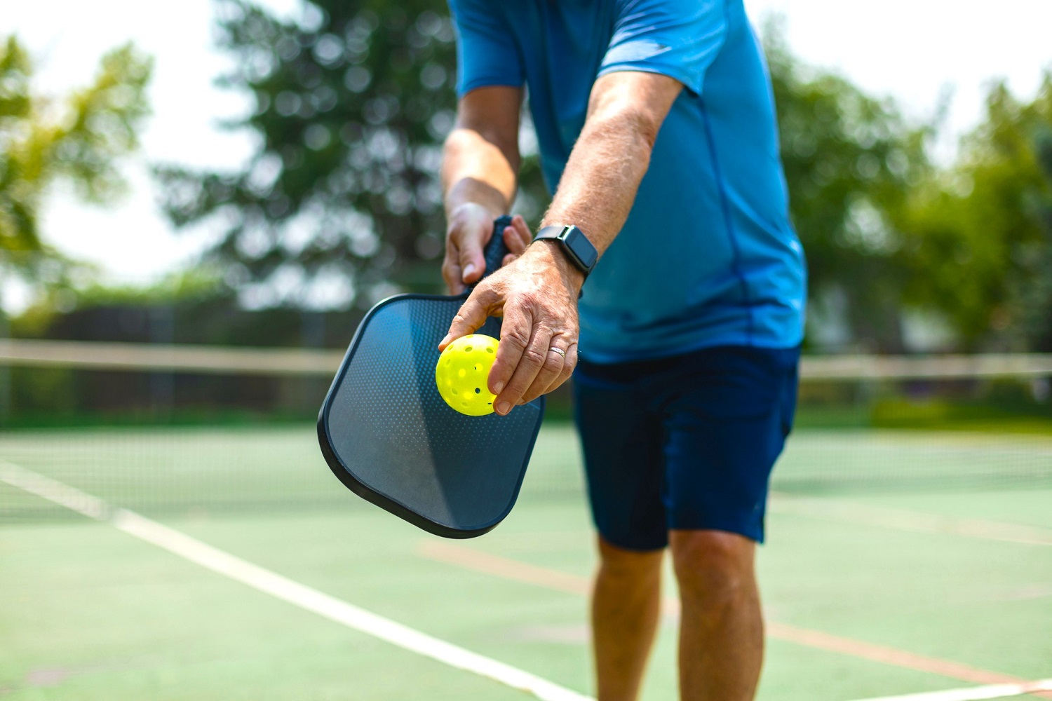 man doing summer activities like playing pickleball outdoors for a fun workout
